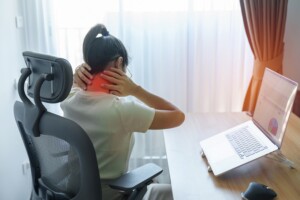 Woman having Neck and Shoulder pain during work 
